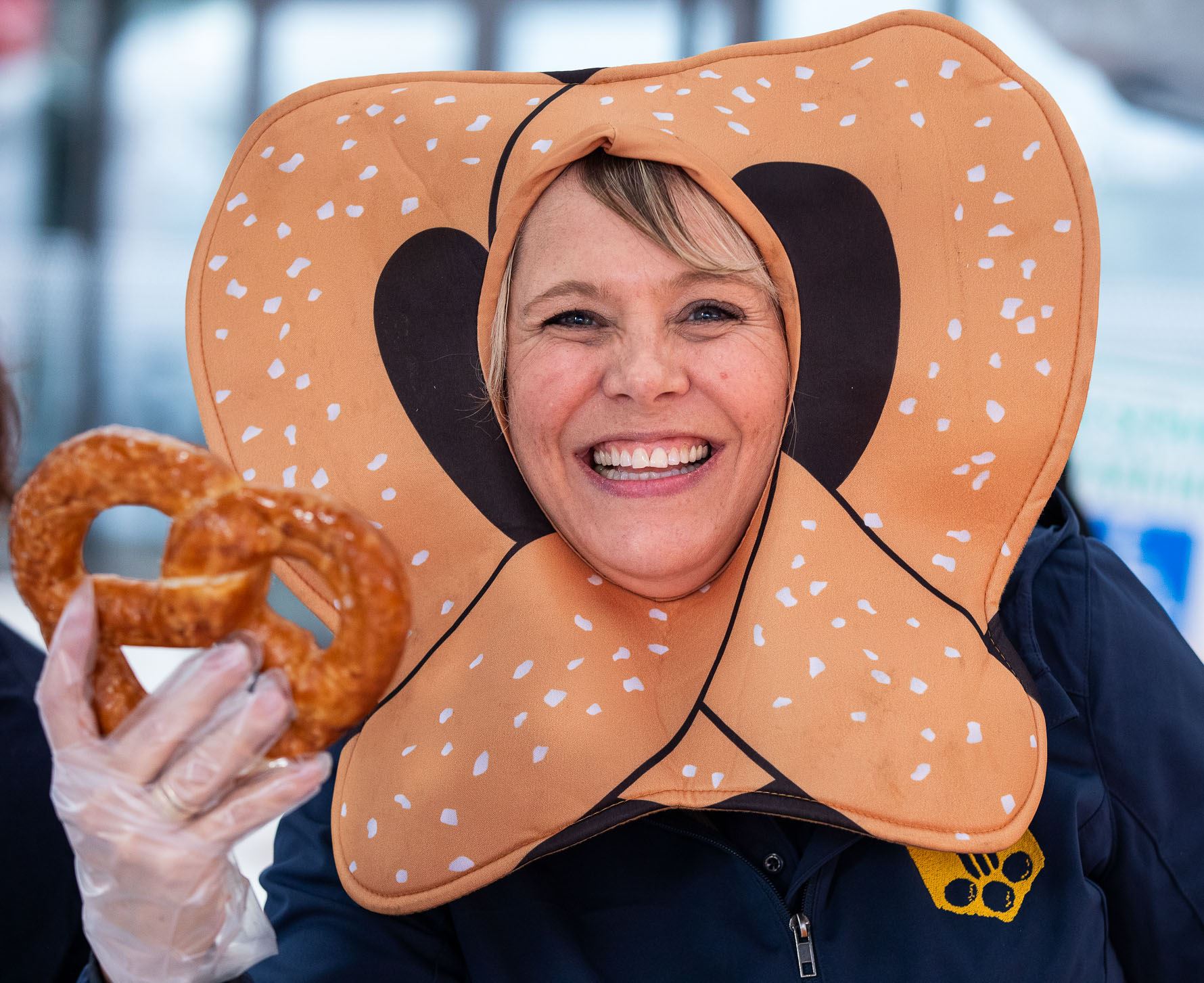 woman wearing a pretzel mask and holding a pretzel 